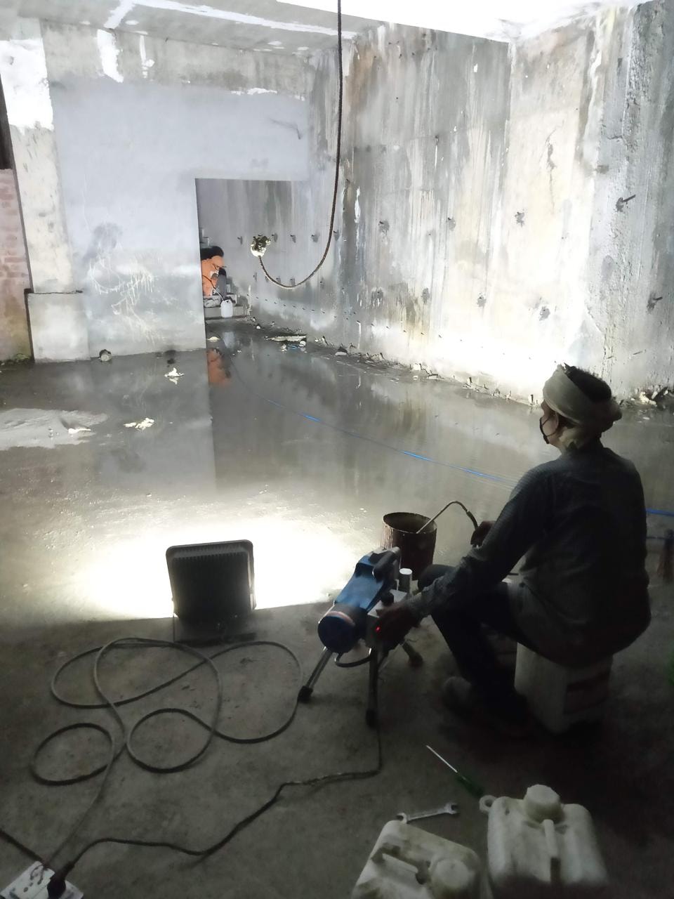 Engineer performing Polyurethane injection in the flooded basement — high-pressure sealing operation