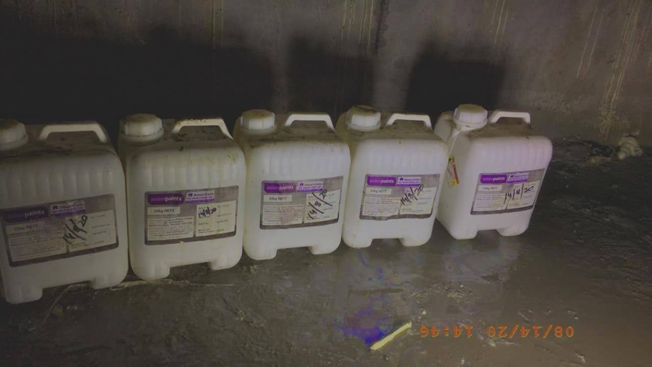 Rows of Asian Paints waterproofing material containers lined up in the basement